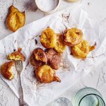 Op het aanrecht liggen enkele pompoenbeignets op een wit boterpapiertje. Ze hebben een mooie oranje gloed, net gouden beignets. Er ligt een vorkje langs meteen te prikken en te eten. 