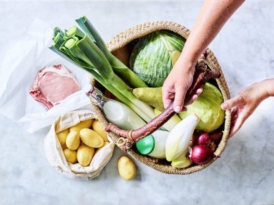 Mand staat op het aanrecht en is gevuld met heerlijke producten van eigen bodem. Denk maar aan prei, witte kool, witloof, yoghurt, uien, krieltjes, varkensvlees... Klaar om meteen aan de slag te gaan. 