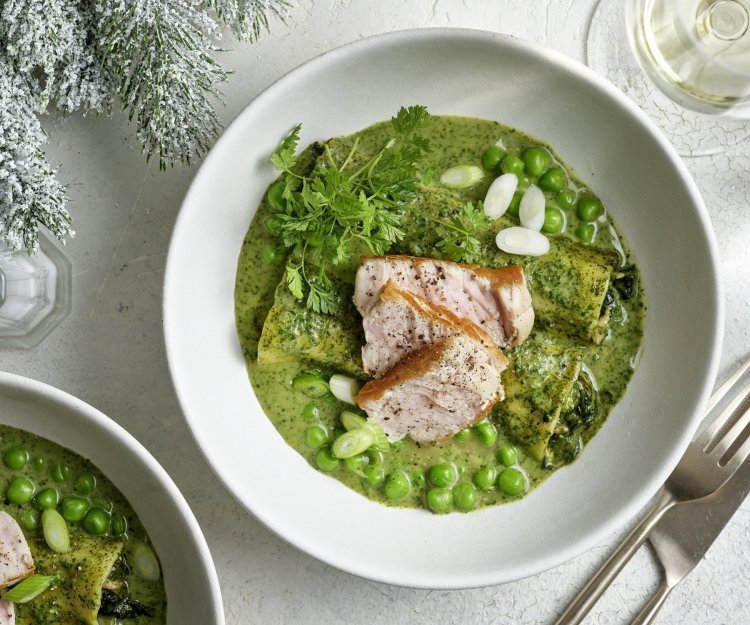 In een diep bord liggen 2 gevulde canneloni, ze liggen in een groen-romig sausje met verse kruiden. Hierbovenop liggen verse kruiden, erwtjes en stukjes kalfsvlees. Een feestelijk en eenvoudig feestgerecht waarbij ieders bord uitlikt. 