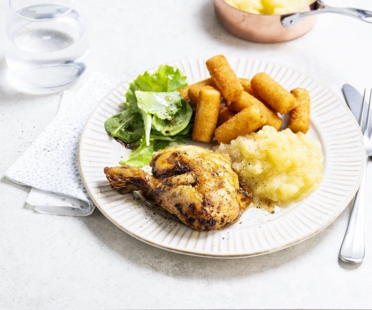 Op tafel staat een bord klaar met een gebraden kippenbout, goudgele appelmoes en kroketten. We serveren deze klassieker met nog wat extra sla en ev nog wat appelmoees. 