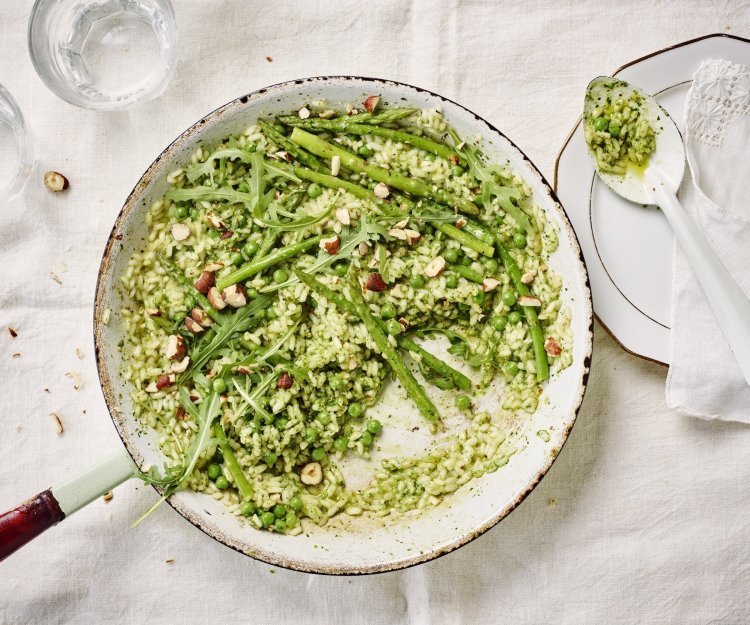 De pan op tafel en scheppen maar. De risotto heeft een mooie groene kleur door de huisgemaakte pesto. We serveren hem met een portie extra groene groentjes zoals erwtjes, groene apserges en rucola.