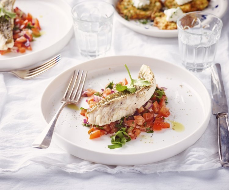 Een rond bordje staat op tafel. De kleurrijke tomatensalsa springt in het oog, hierop ligt een stukje vis. Rode poon, lekker van bij ons.  