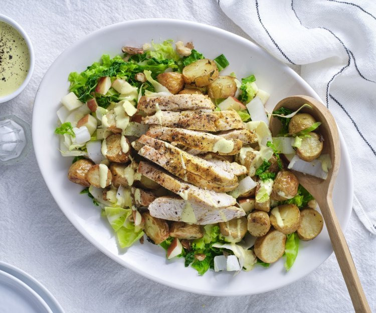 Een groot bord is rijkelijk gevuld met stukjes groenten, fruit, aardappel en gebakken kip. Hij is afgewerkt met een heerlijke currydressing. Schep maar op, zou ik zeggen. 