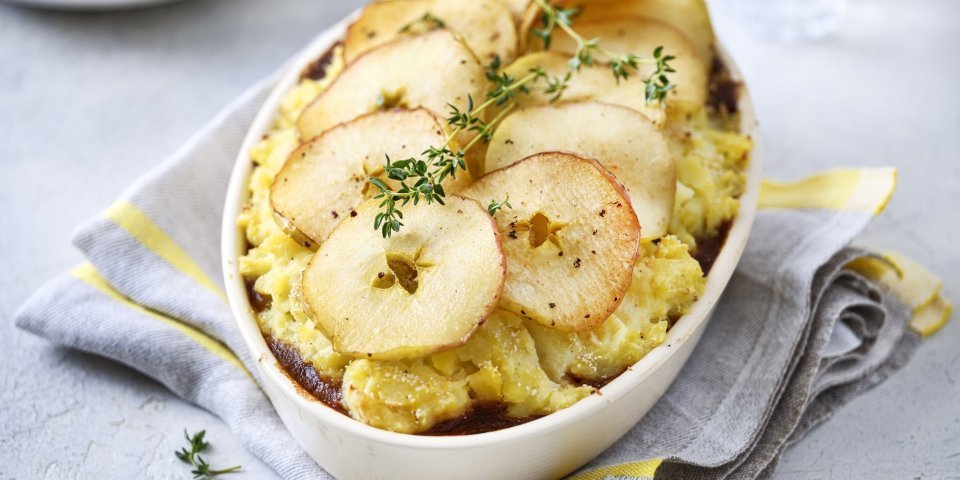 Op tafel staat een ovale witte ovenschotel gevuld met onderaan het stoofpotje, hierop de aardappelpuree en tenslotte de appelschijfjes. Dit geeft een mooi beeld, niet alleen om naar te kijken ook om meteen te beginnen eten. Het gerechtje werd afgewerkt met verse takjes tijm. 