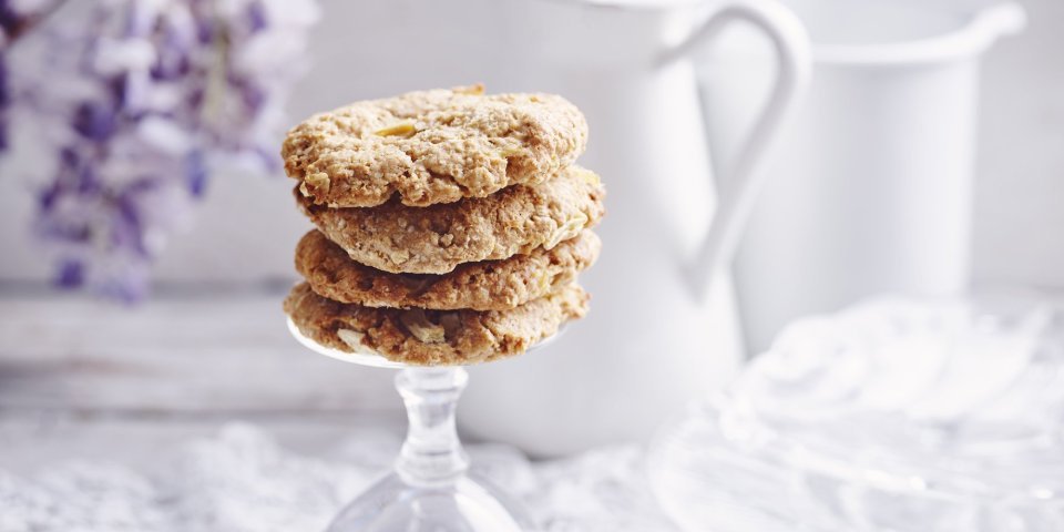 Heerlijke homemade cookies. Wij maakte er met appeltjes en pindakaas, een topcominatie. Ze liggen op de voet van een omgedraaid wijnglas. Achteraan de foto vind je een bloem van een Blauwe regen, melkkan en koffiekan. 