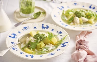 Een wit bord met blauwe kipjes op de rand is gevuld met heerlijke verse kippensoep. Het is een echte maaltijdsoep, met stukjes kip, aardappelen en prei. We werkten de soep af met een scheutje room in het bord en schep rucolapesto. Echt lekker! 