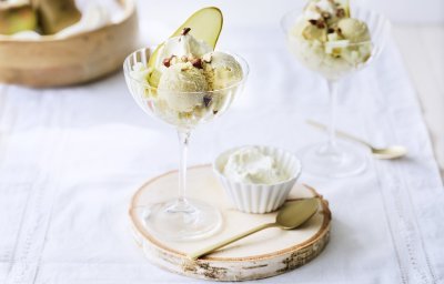 Op tafel staan twee ijsjes uitgeschept in een feestelijk wijnglas, dit zorgt voor een extra feestboost. Het ijsje is afgewerkt met een schijfjes peer en gehakte nooitjes. 