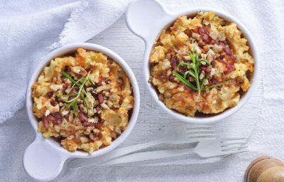 Op tafel staan 2 potjes uitgeschept als bijgerecht. Ze zijn gevuld met een heerlijke aardappelpuree met wortel en afgewerkt met stukjes spek, noten en salie. 