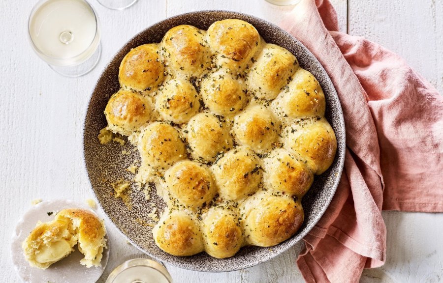 In het midden van de tafel vind je een groot rond keramiek bord in aardekleur. Hierin liggen de goudgele briochebroodjes met knoflookboter, en gevuld zijn met abdijkaas. Instant feestlook en heerlijk smaakvol als bijgerecht.  