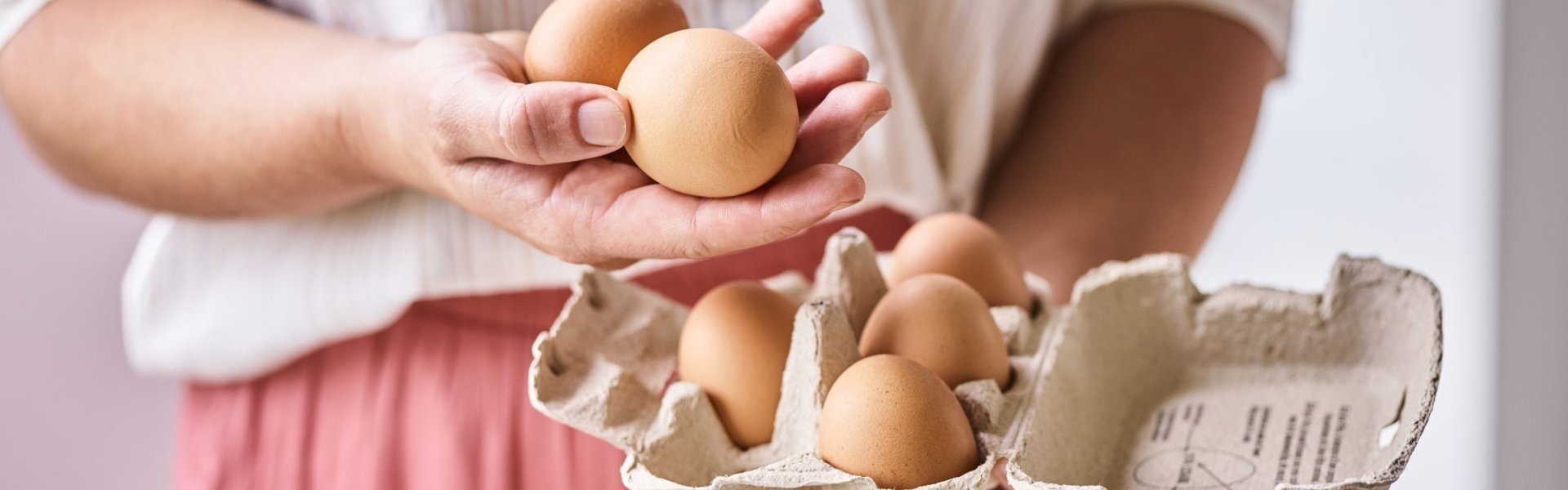 Vrouw houdt een doosje eieren vast