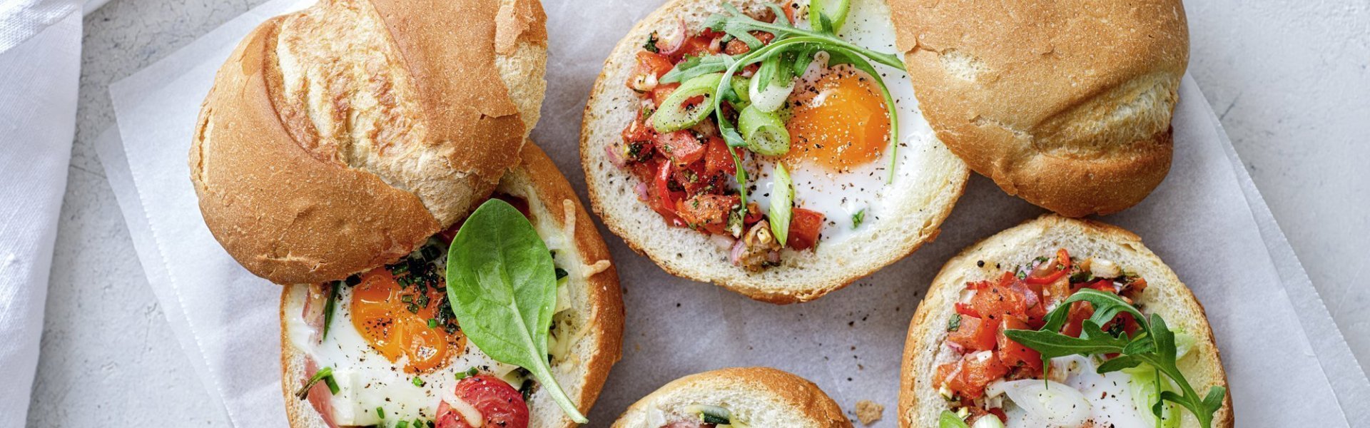 Gevulde broodjes met een eitje erin, staan op tafel te blinken! We maakte een versie met gekookte ham, courgette en tomaatjes. En onze tweede is er eentje met pittige tomatensalsa en rucola, heerlijk!  